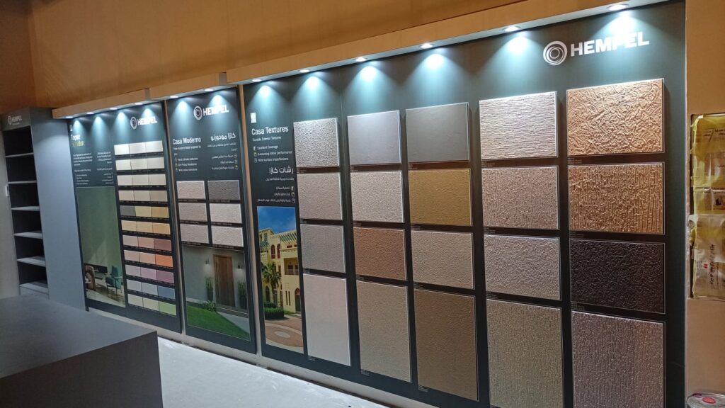 المنظر الداخلي لمعرض همبل الشويخ، يعرض جدار رشات كازا (Casa Textures) و كازا مودرنو (Casa Moderno) لـ اصباغ همبل الخارجية ودهانات ديكور المناسبة لـ اصباغ المنازل من الداخل.